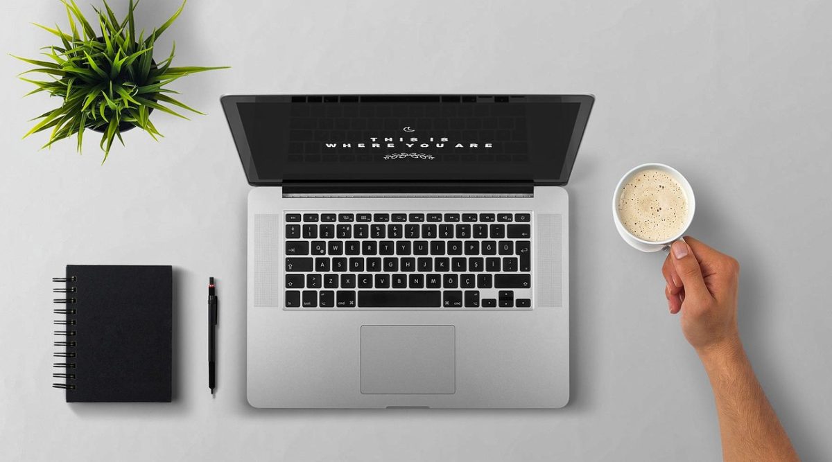 Laptop, coffee, arm — Roger Gallagher Miami: Delivering Tailored Financial Solutions for the Elite